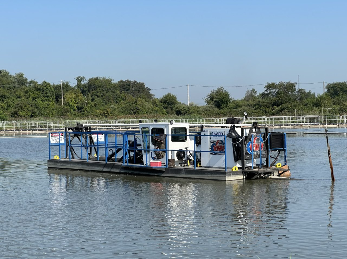 Dredging equipment removing sludge and sediment from a lagoon